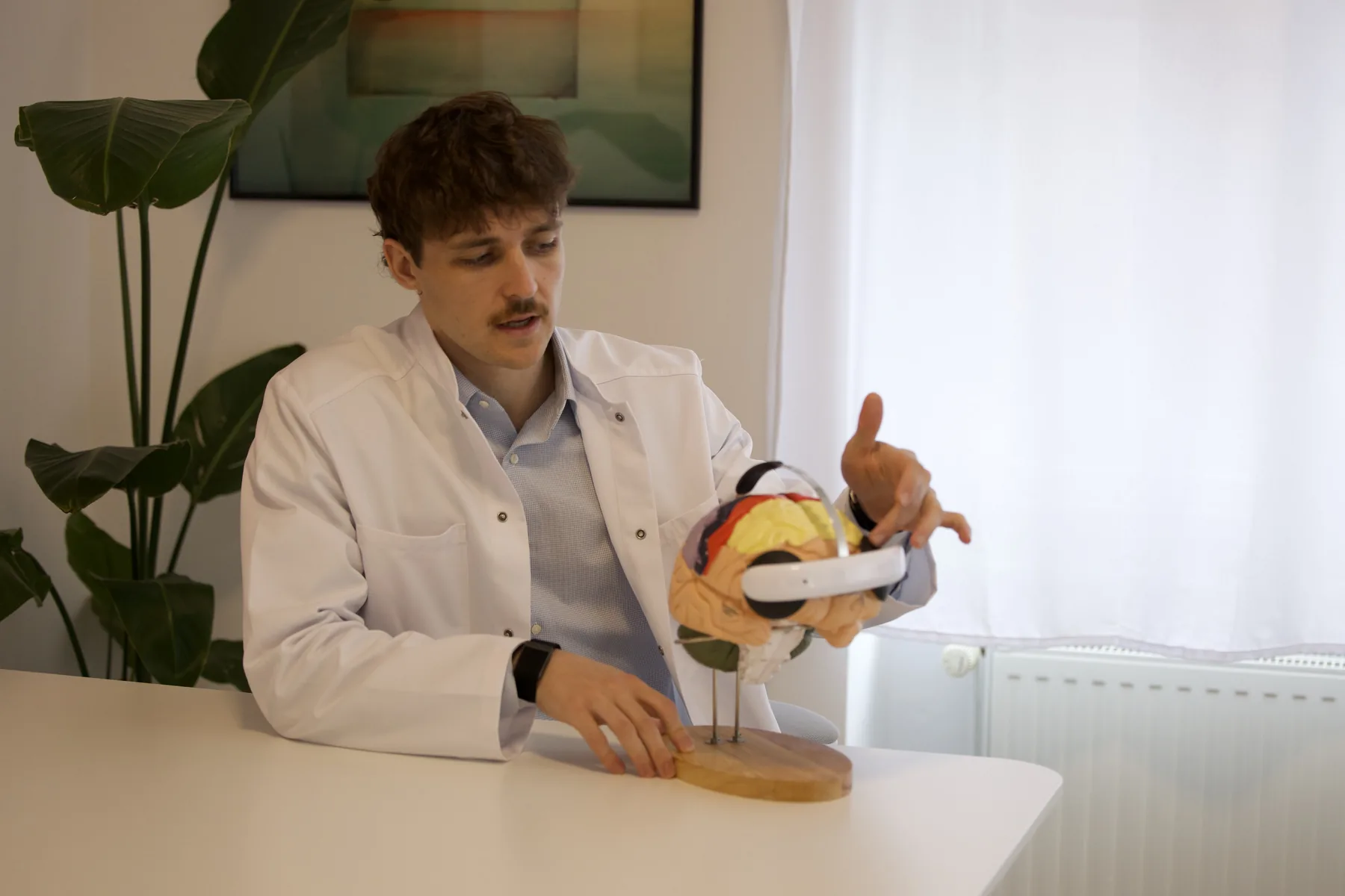 Dr. Tim Schwarz erklärt das Flow-Headset für die tDCS am Gehirnmodell